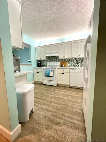 a kitchen with a sink stove top oven and refrigerator