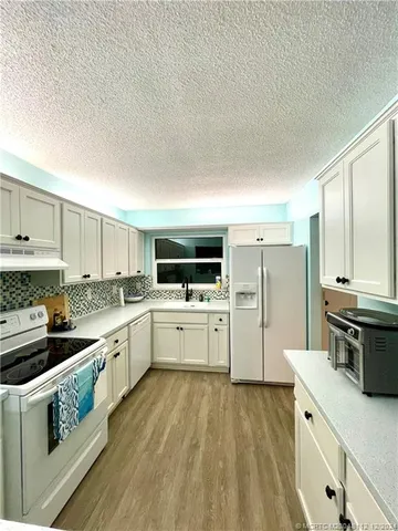 a living room with a bed furniture and a wooden floor