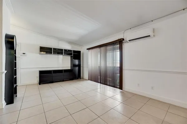 a view of an empty room with wooden cabinet