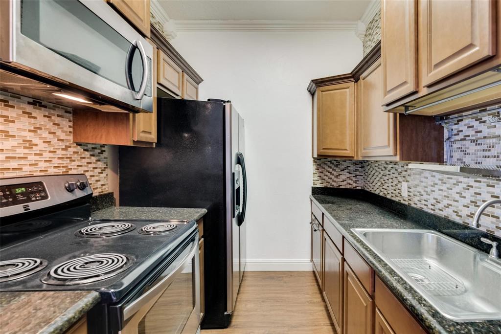 2627 Douglas Avenue, Unit 205 Dallas, TX 75219 - Photo 7 of 17 a kitchen with stainless steel appliances granite countertop a sink stove and refrigerator