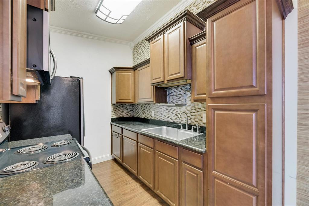 2627 Douglas Avenue, Unit 205 Dallas, TX 75219 - Photo 8 of 17 a kitchen with stainless steel appliances granite countertop a refrigerator sink and stove