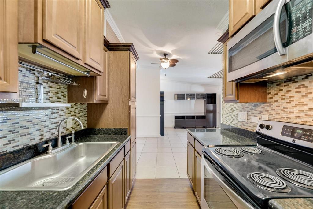 2627 Douglas Avenue, Unit 205 Dallas, TX 75219 - Photo 9 of 17 a kitchen with stainless steel appliances granite countertop a sink stove and refrigerator