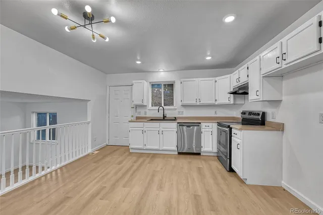 a kitchen with stainless steel appliances sink cabinets and wooden floor
