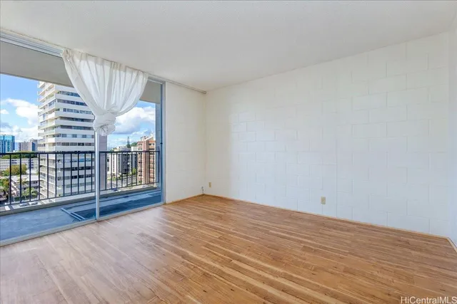 a view of an empty room with wooden floor
