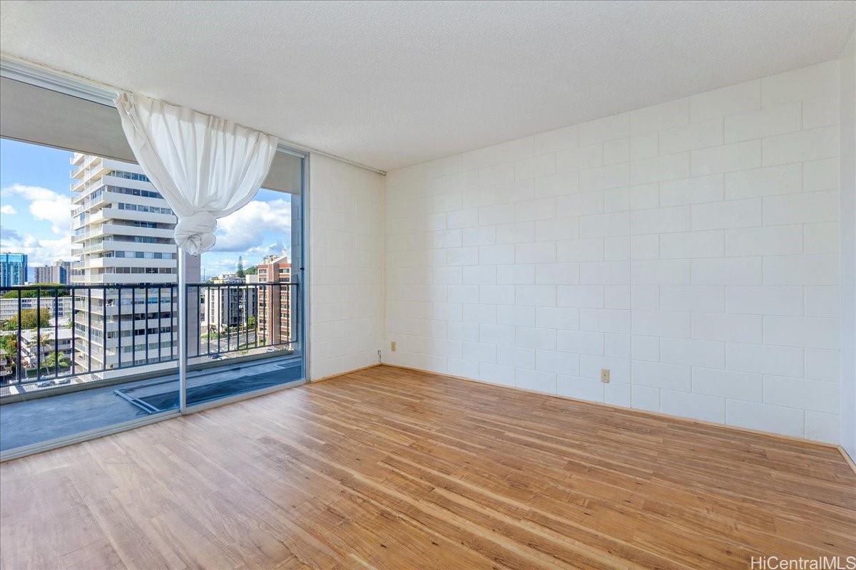 1420 Victoria Street, Unit 1301 Honolulu, HI 96822 - Photo 15 of 20 a view of an empty room with wooden floor