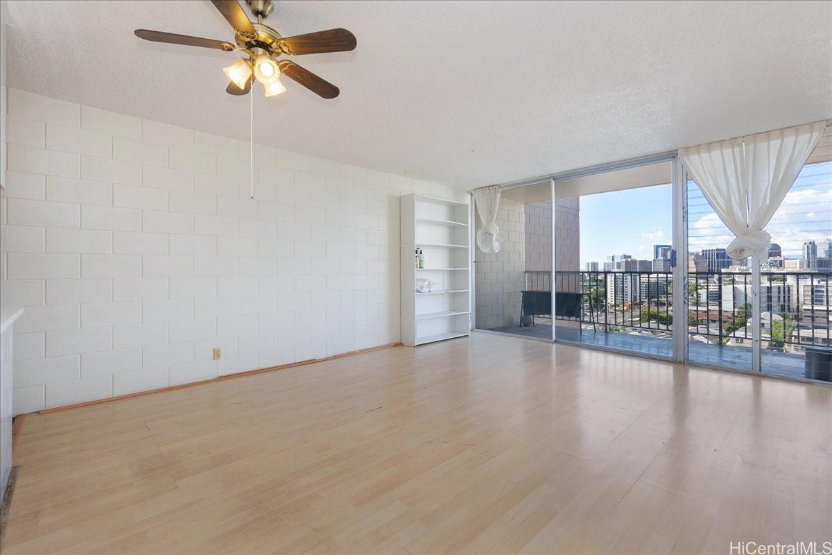 1420 Victoria Street, Unit 1301 Honolulu, HI 96822 - Photo 4 of 20 an empty room with wooden floor fan and windows