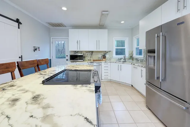 a kitchen with a sink a refrigerator and cabinets