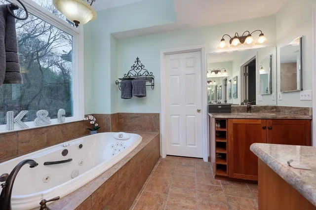 a bathroom with a tub sink and mirror