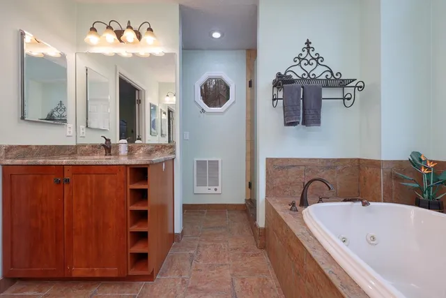 a bathroom with a tub sink and mirror