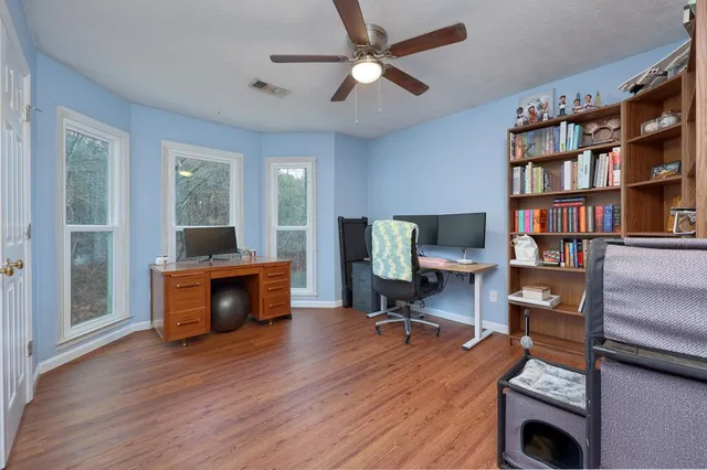 a view of a workspace with furniture and a bookshelf
