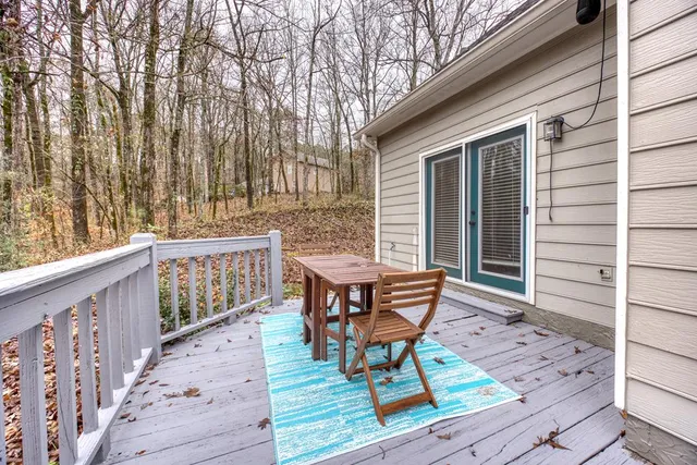 a balcony with wooden floor and outdoor seating