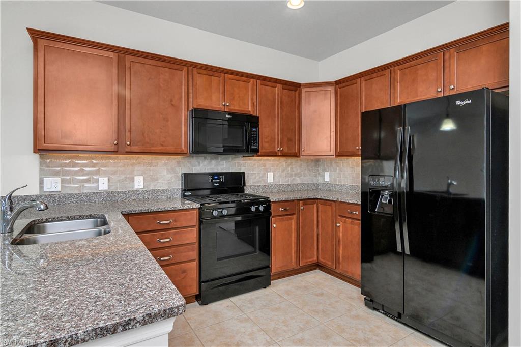 20179 Torch Key Way Estero, FL 33928 - Photo 5 of 25 a kitchen with stainless steel appliances granite countertop a stove a sink and a microwave