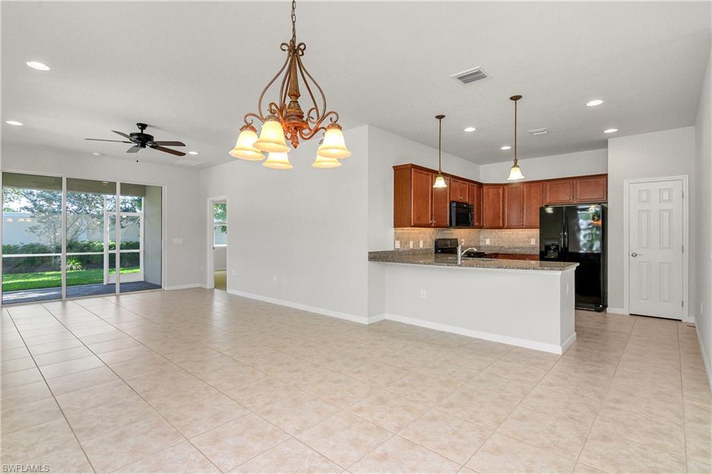 20179 Torch Key Way Estero, FL 33928 - Photo 7 of 25 a view of large kitchen with stainless steel appliances granite countertop a stove a sink a refrigerator and a living room view