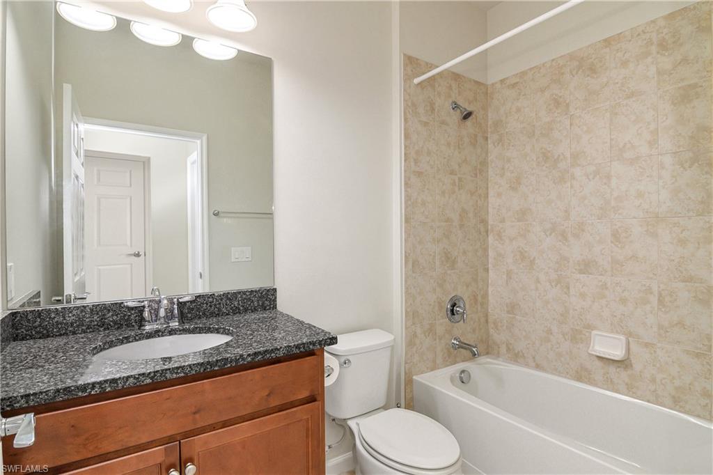 20179 Torch Key Way Estero, FL 33928 - Photo 10 of 25 a bathroom with a granite countertop sink a toilet and bathtub