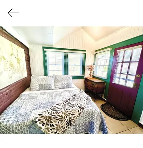 a bedroom with a bed windows and wooden floor