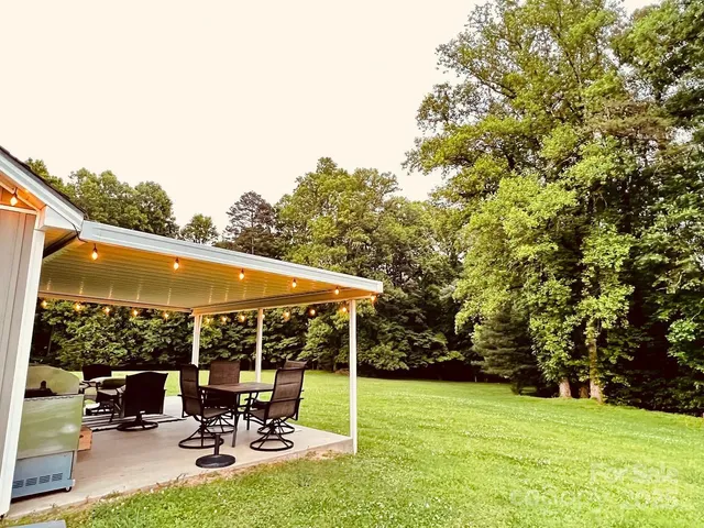 a view of a patio with table and chairs under an umbrella