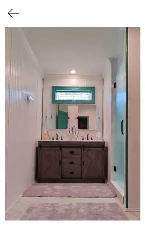 a bathroom with a sink vanity and mirror