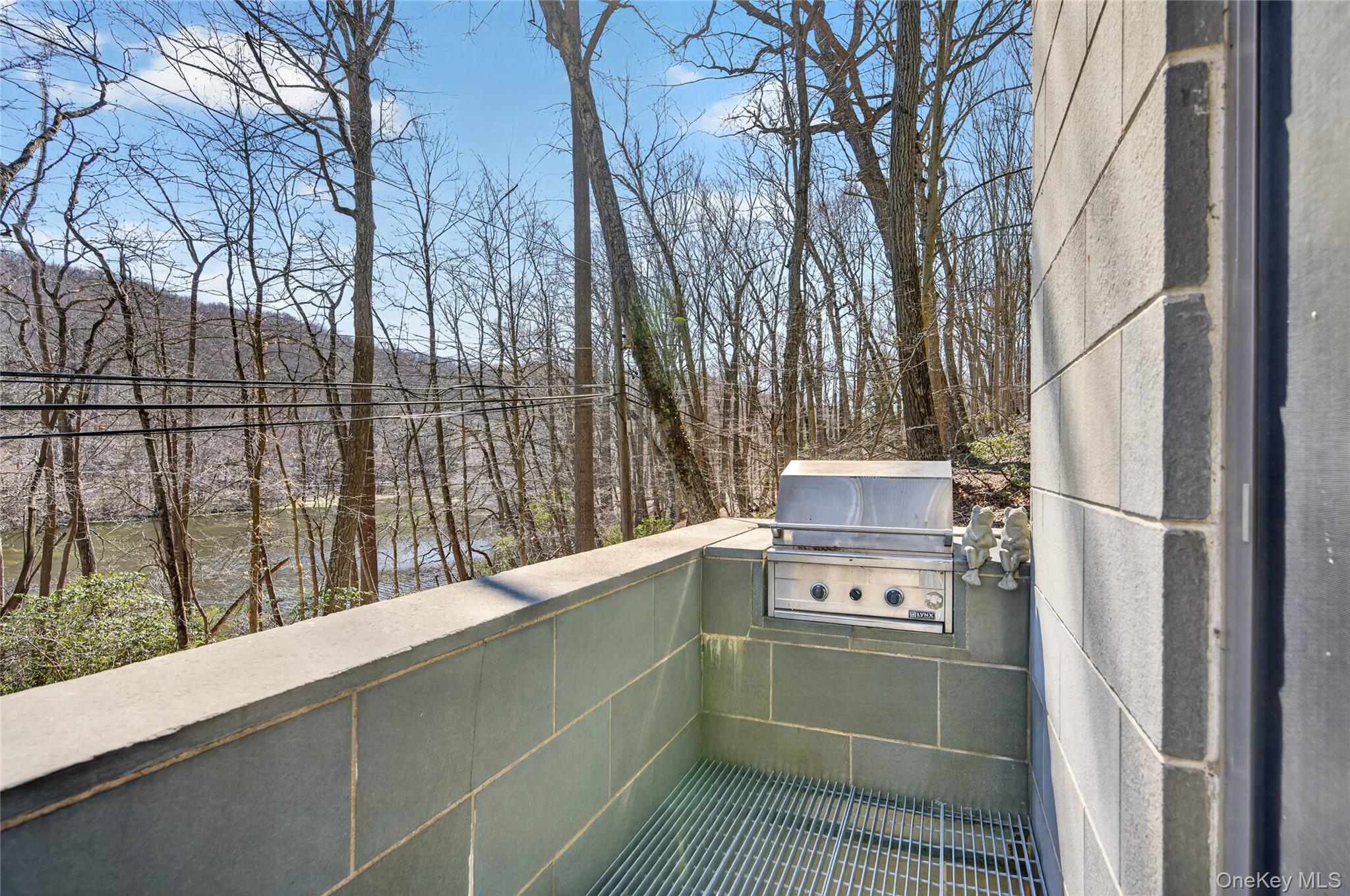 428 Harbor Road, Unit C Syosset, NY 11791 - Photo 15 of 29 Outdoor cooking area featuring an integrated stainless steel grill and stone-tiled walls