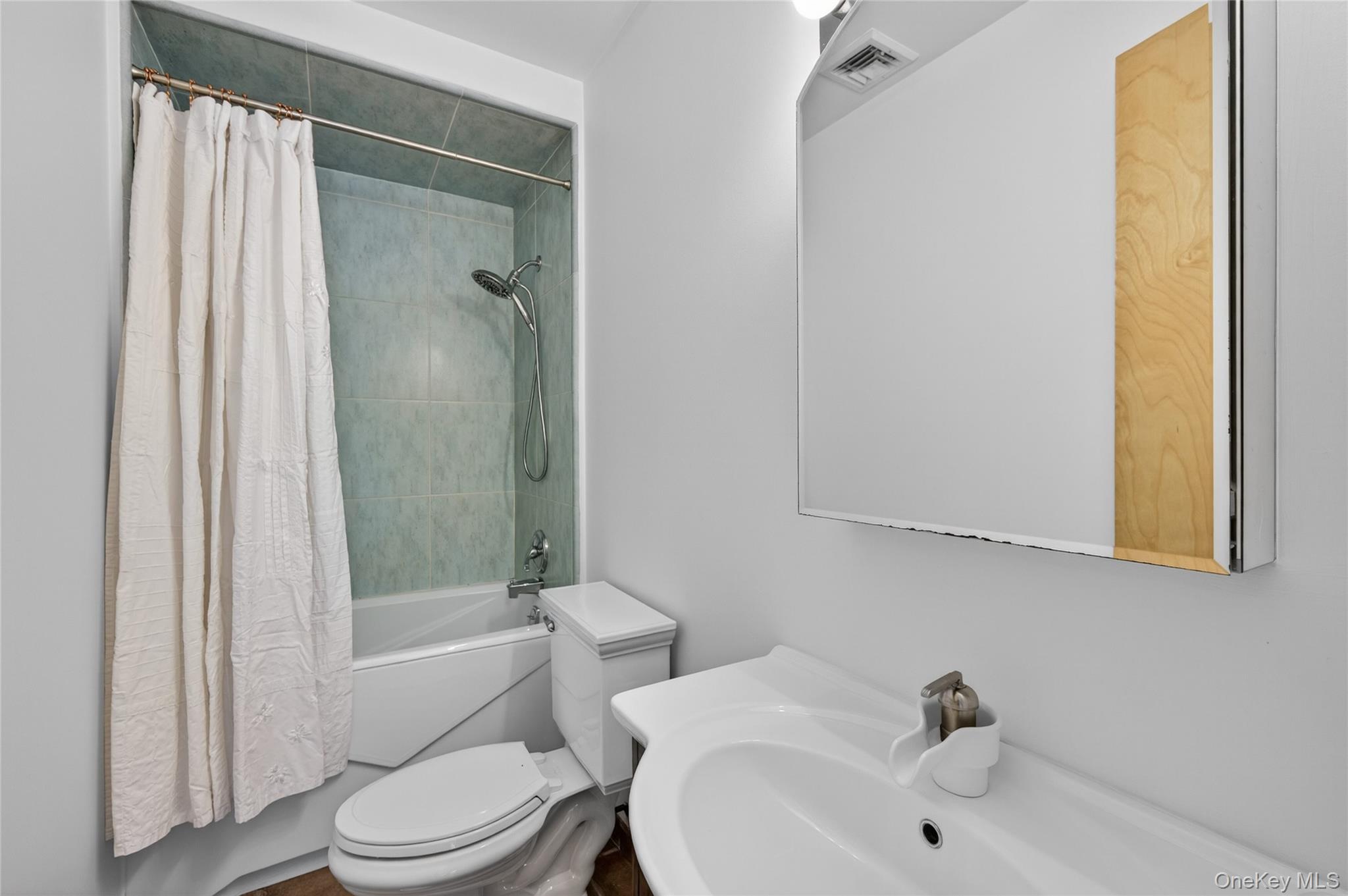 428 Harbor Road, Unit C Syosset, NY 11791 - Photo 20 of 29 Bathroom featuring a white vanity with integrated sink, large mirrored medicine cabinet, and a shower-over-tub combination with light-toned wall tiling