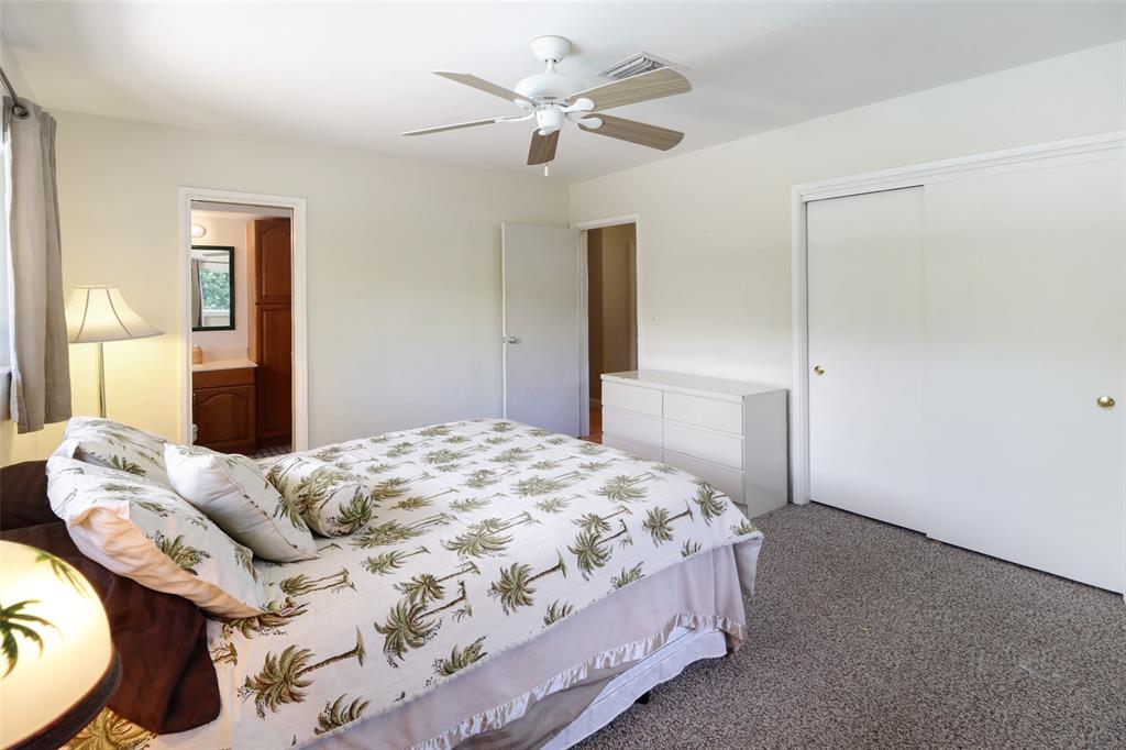 2517 Northeast 26th Terrace Fort Lauderdale, FL 33305 - Photo 16 of 42 a bedroom with a bed and a chandelier