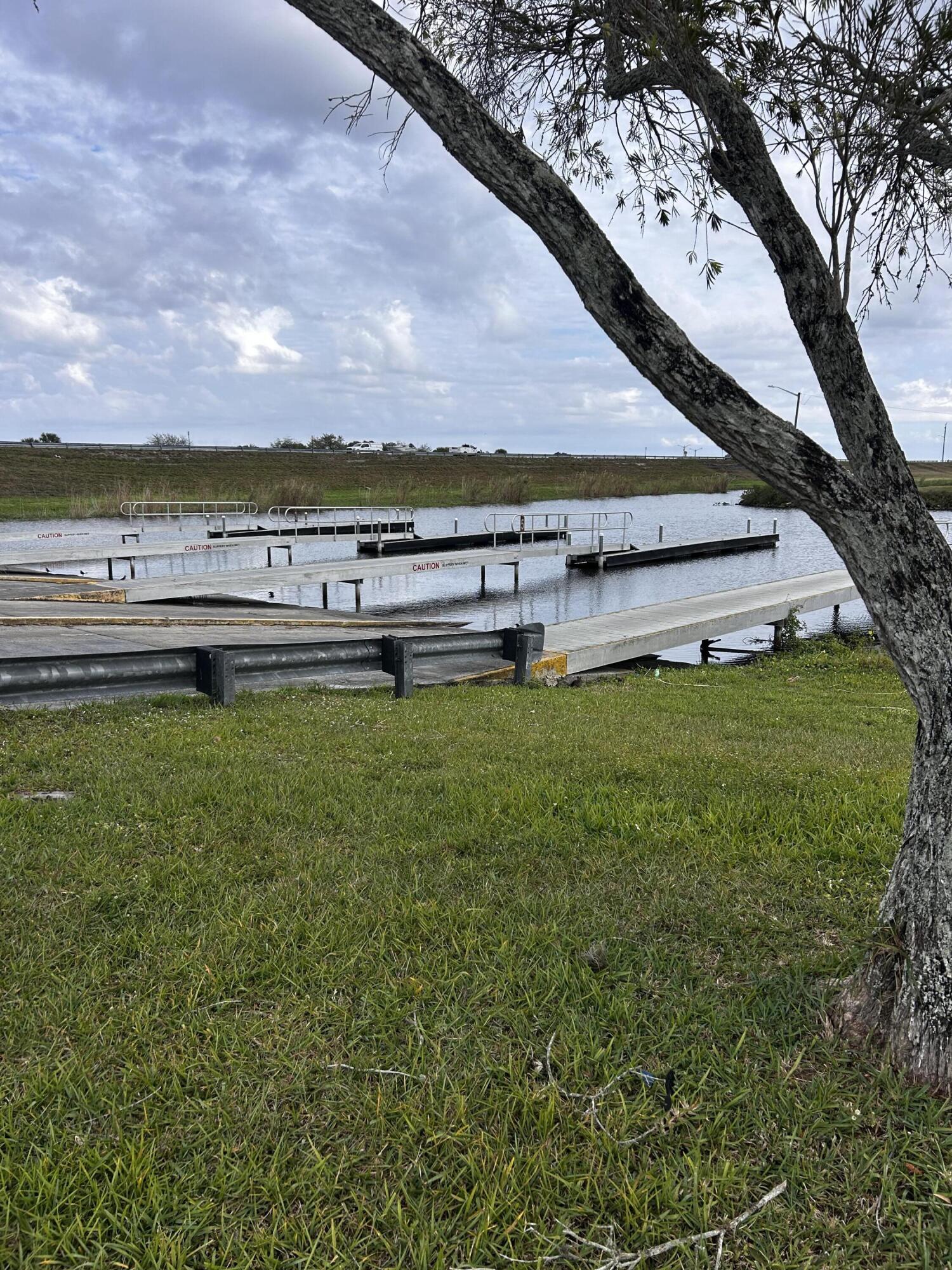 425 South Quebrada Street Clewiston, FL 33440 - Photo 37 of 56 a view of a large pool with a yard and a mountain in the background
