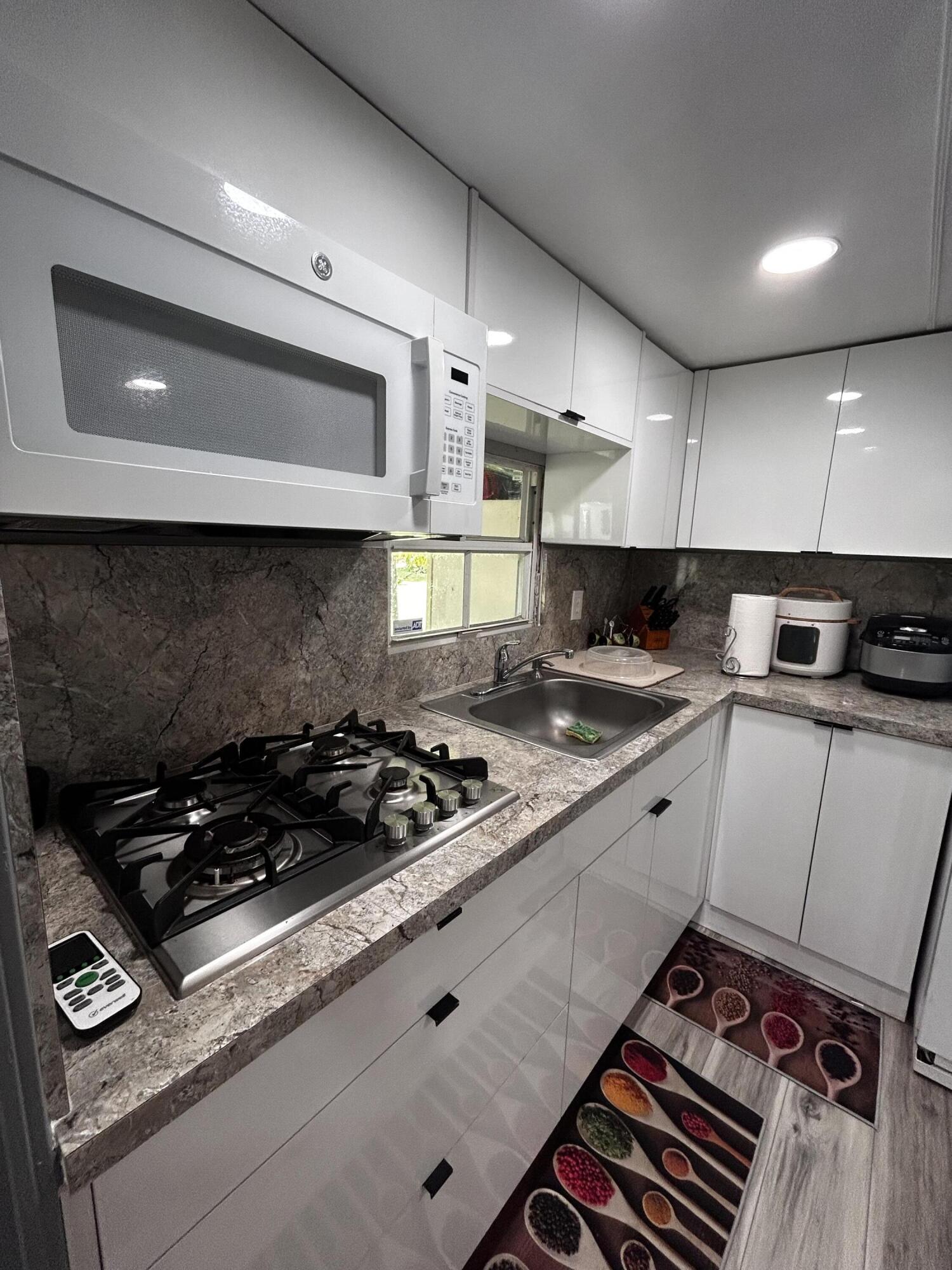 425 South Quebrada Street Clewiston, FL 33440 - Photo 6 of 56 a kitchen with a stove a sink and a microwave