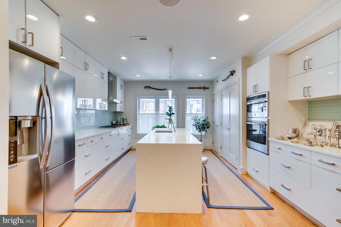 117 T Street Northwest, Unit 2 Washington, DC 20001 - Photo 10 of 32 a large kitchen with stainless steel appliances kitchen island granite countertop a refrigerator and cabinets