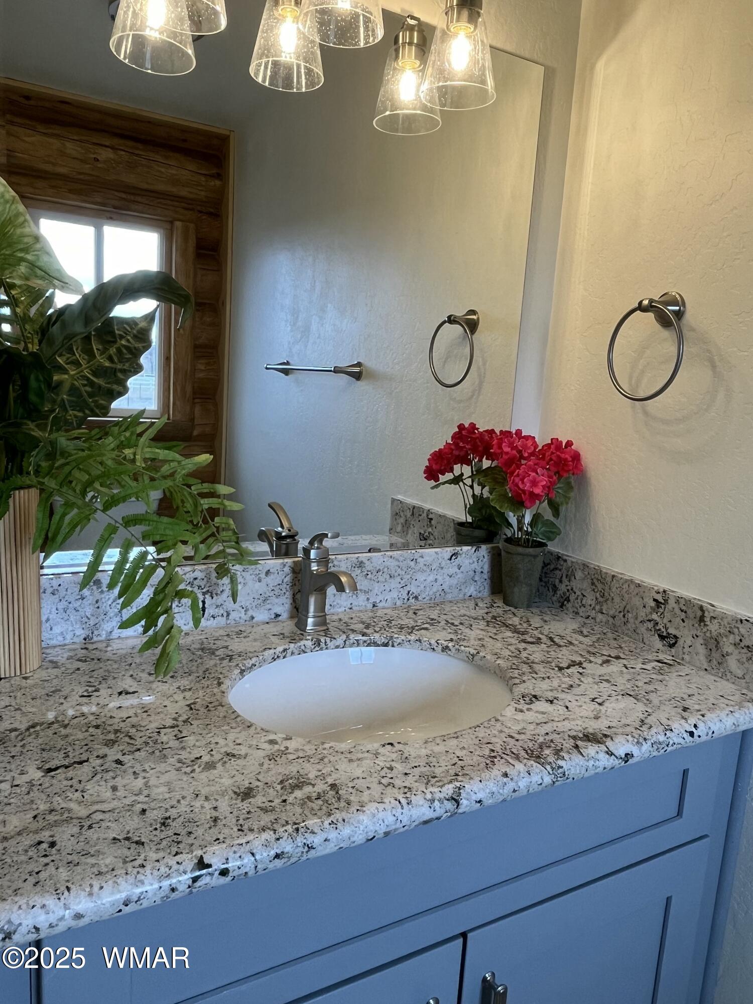 446 Becker Lake Road Springerville, AZ 85938 - Photo 16 of 18 a bathroom with a granite countertop sink a mirror and shower