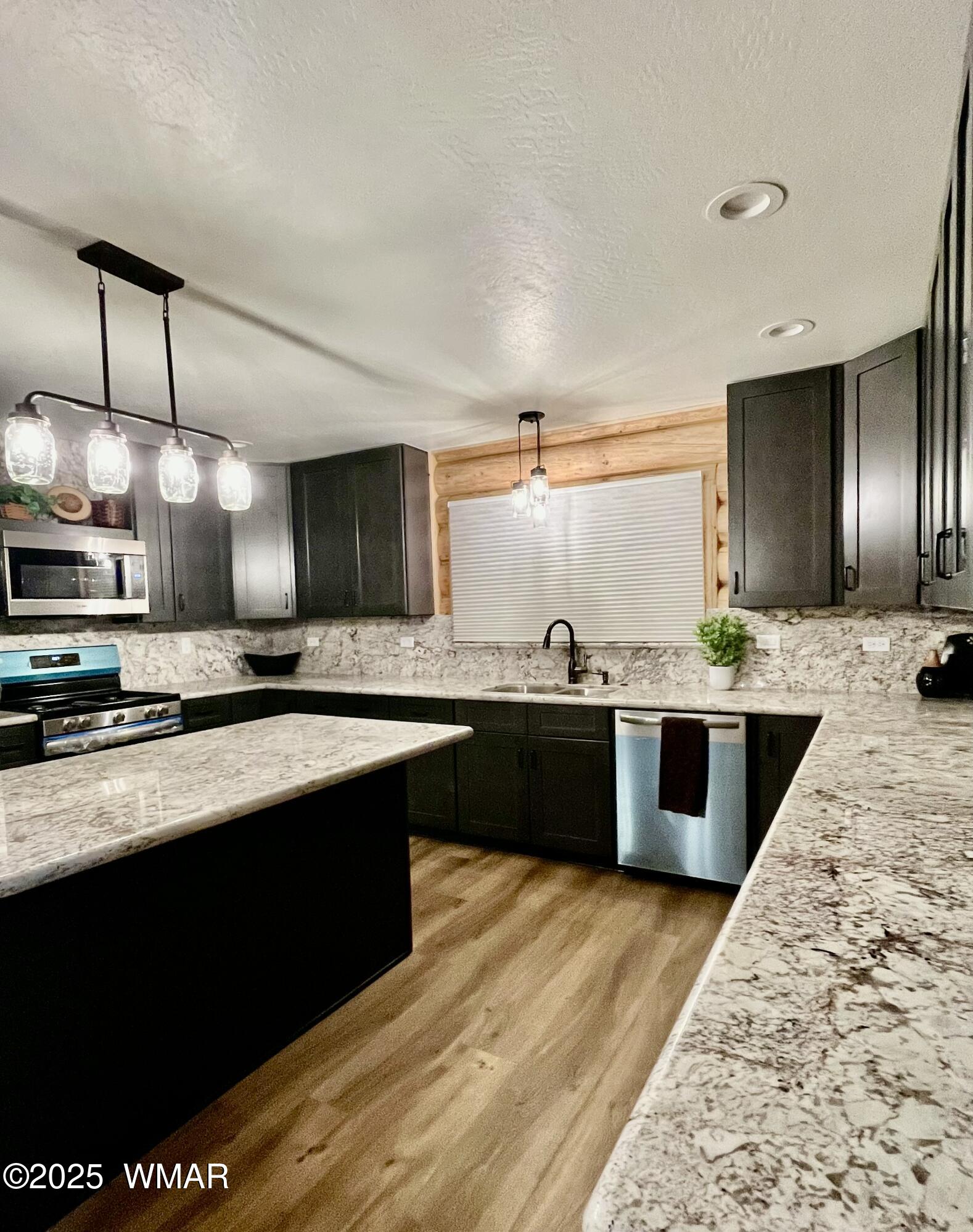446 Becker Lake Road Springerville, AZ 85938 - Photo 7 of 18 a large kitchen with stainless steel appliances kitchen island granite countertop a sink counter space and cabinets