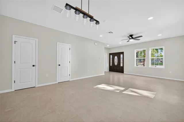 a view of an empty room with a window and fireplace
