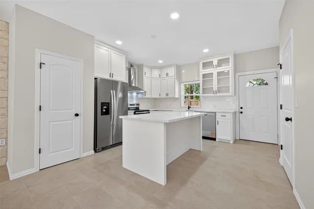 a kitchen with white cabinets and sink