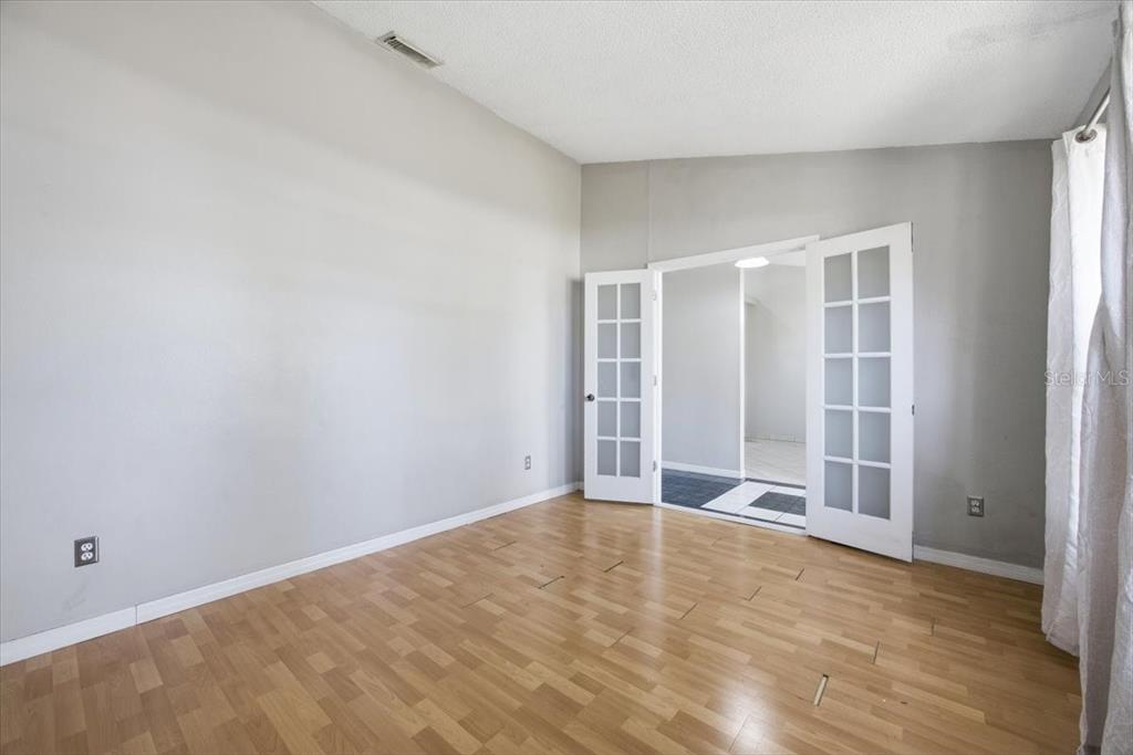 364 Nevada Loop Road Davenport, FL 33897 - Photo 4 of 26 an empty room with wooden floor and windows