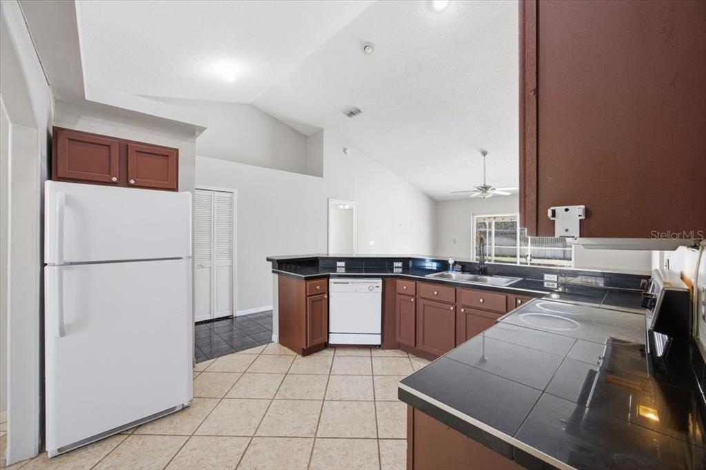 364 Nevada Loop Road Davenport, FL 33897 - Photo 7 of 26 a kitchen with a sink a stove top oven and kitchen island
