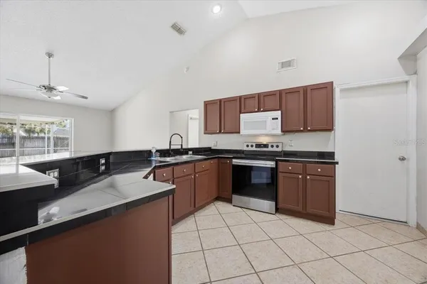 a kitchen with granite countertop a sink and a stove