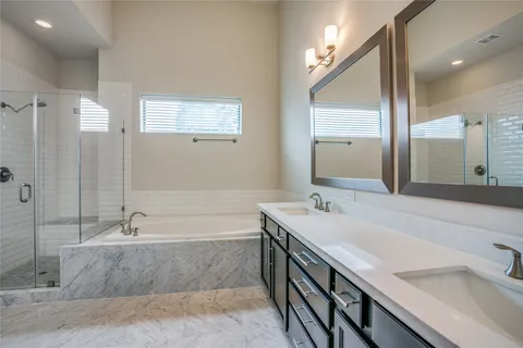 a bathroom with a tub a sink and mirror
