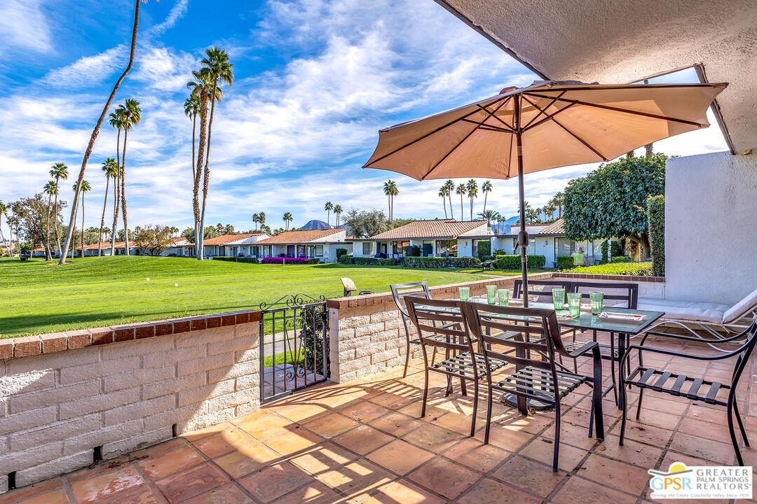 28 Calle Encinitas Rancho Mirage, CA 92270 - Photo 14 of 57 a patio with a table and chairs under an umbrella