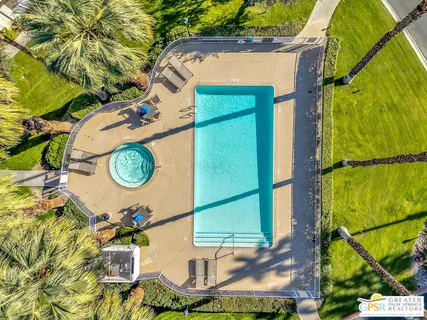 a view of a swimming pool with a patio and a yard