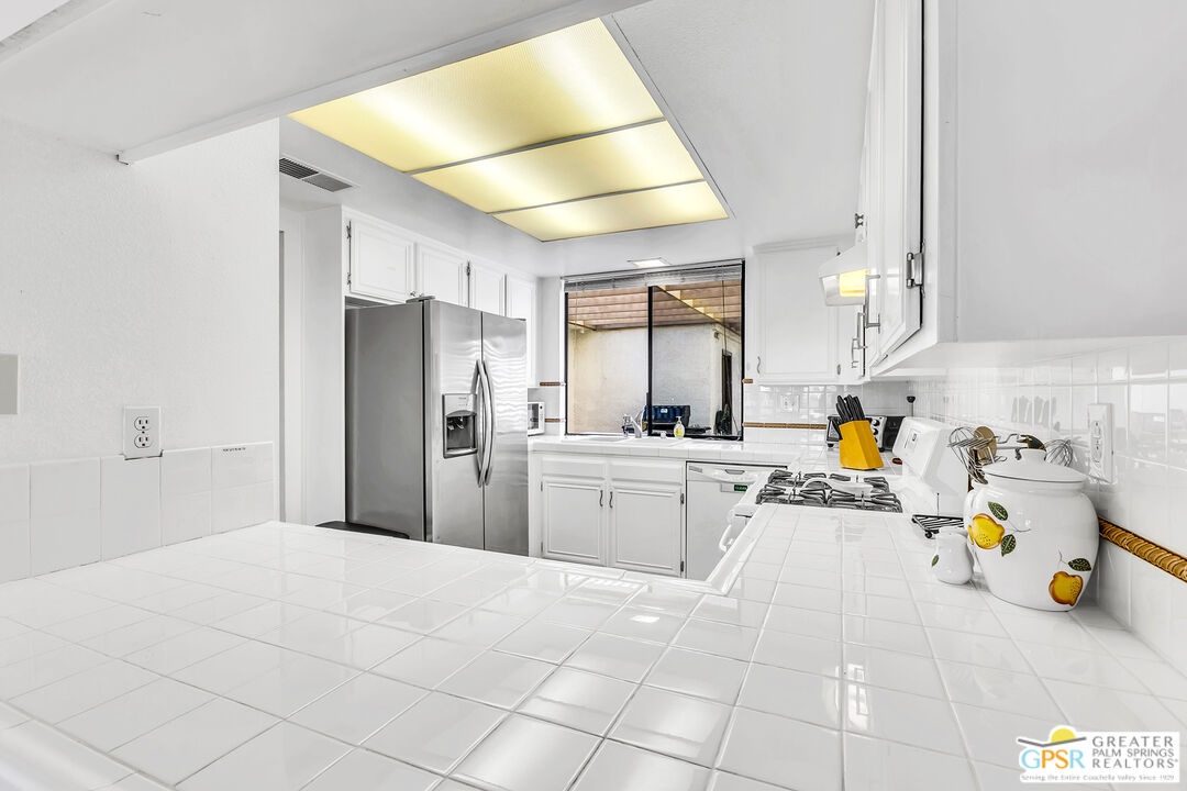 28 Calle Encinitas Rancho Mirage, CA 92270 - Photo 37 of 57 a kitchen with a sink a refrigerator and wooden cabinets