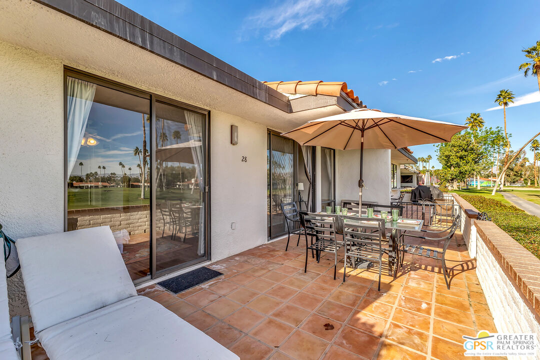 28 Calle Encinitas Rancho Mirage, CA 92270 - Photo 51 of 57 a patio with a table and chairs under an umbrella