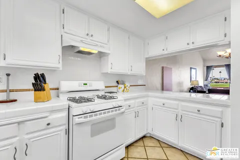 a kitchen with white cabinets and appliances