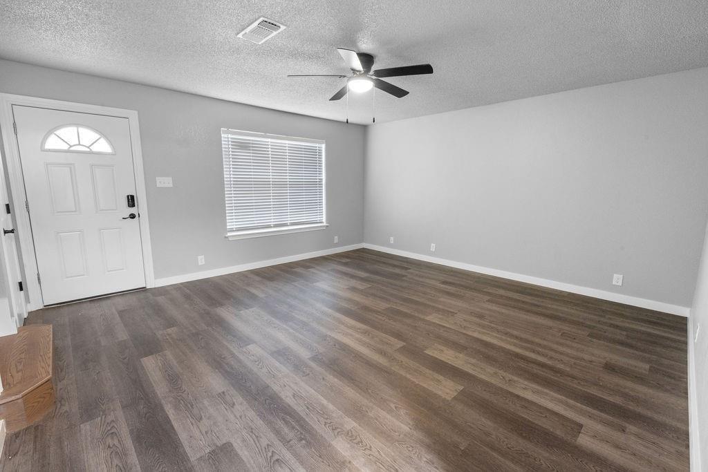 709 East Crawford Street Denison, TX 75021 - Photo 2 of 13 wooden floor in an empty room with a window