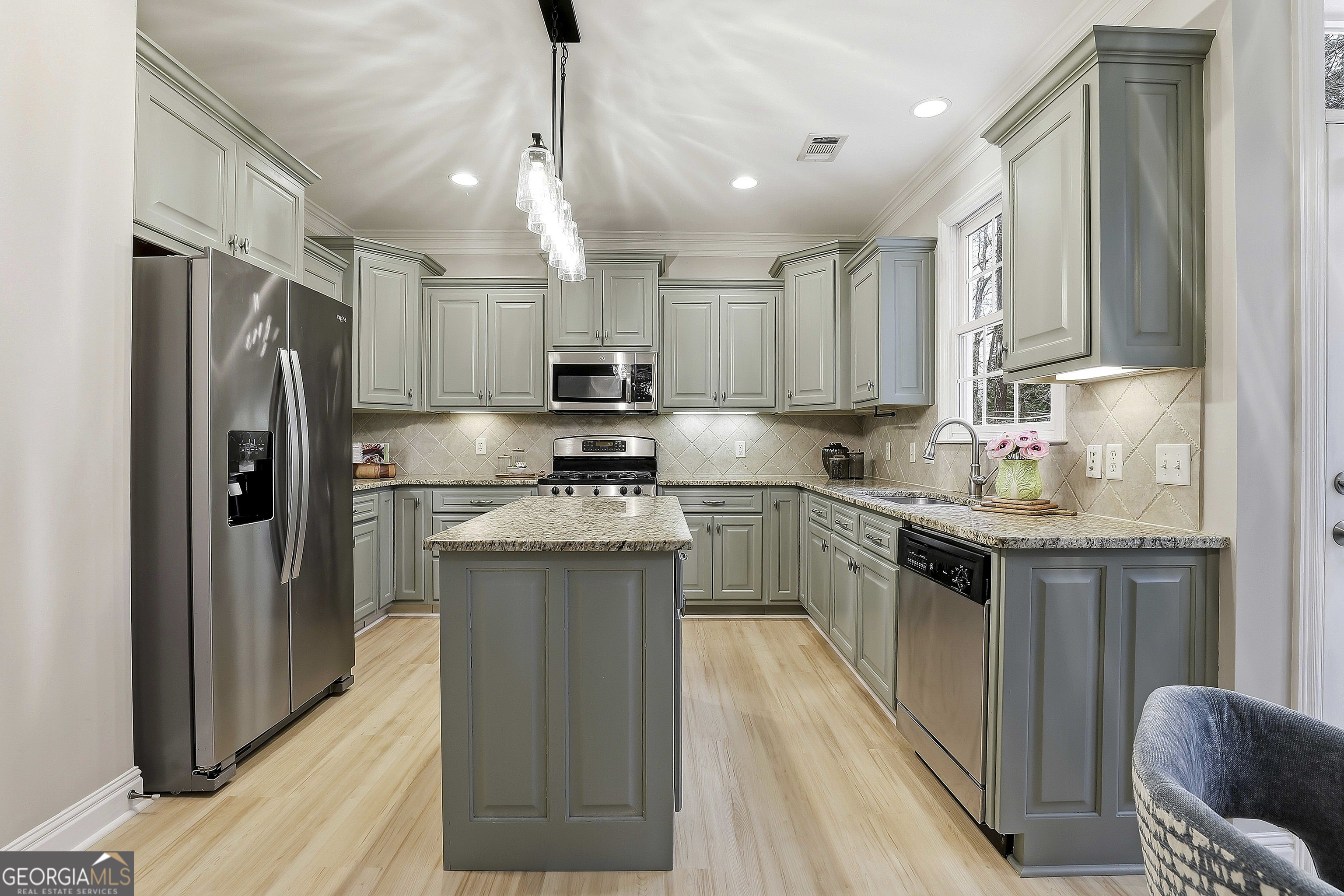 108 Tullamore Trail Tyrone, GA 30290 - Photo 27 of 54 a kitchen with kitchen island a refrigerator a stove a sink dishwasher and white cabinets with wooden floor