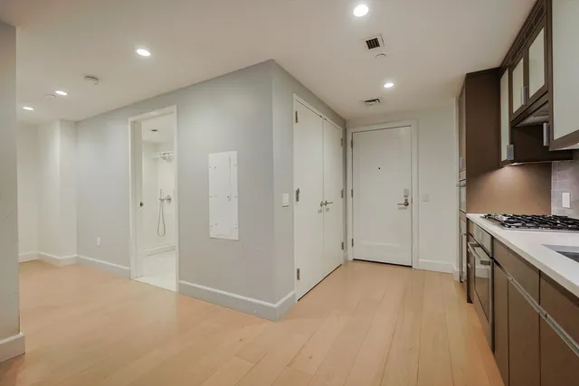 a view of a kitchen with stainless steel appliances granite countertop a refrigerator and a stove top oven