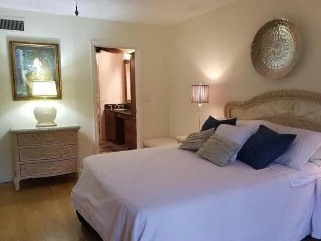 a bedroom with a bed and a lamp on dresser