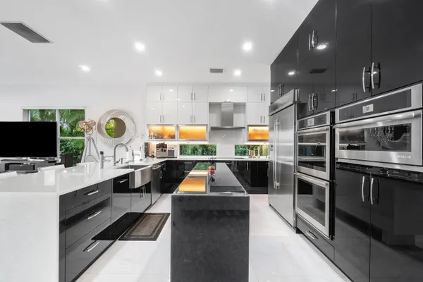 a kitchen with stainless steel appliances kitchen island granite countertop a stove and a sink