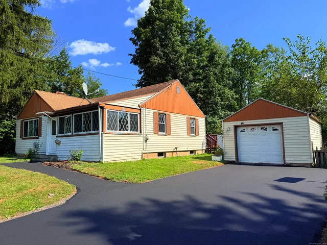 a front view of a house with a yard and trees