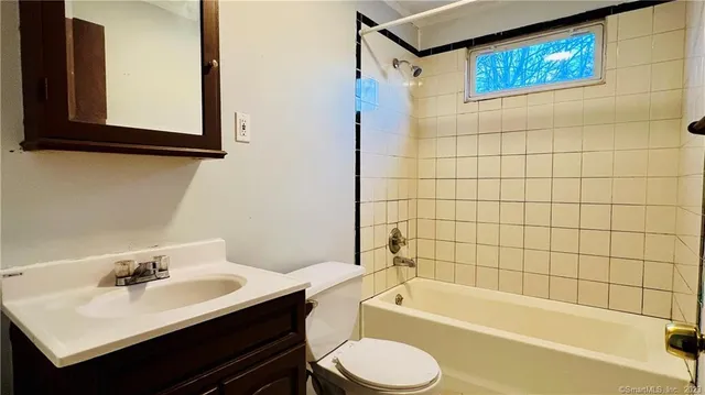 a bathroom with a sink mirror toilet and bathtub
