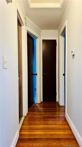 a view of a hallway with wooden floor and closet