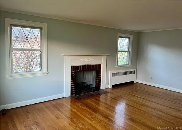 an empty room with windows and a fireplace