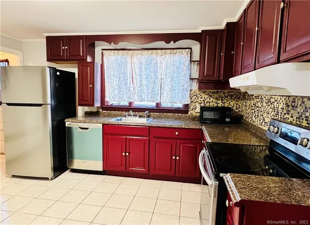 a kitchen with stainless steel appliances granite countertop a stove a refrigerator and a oven